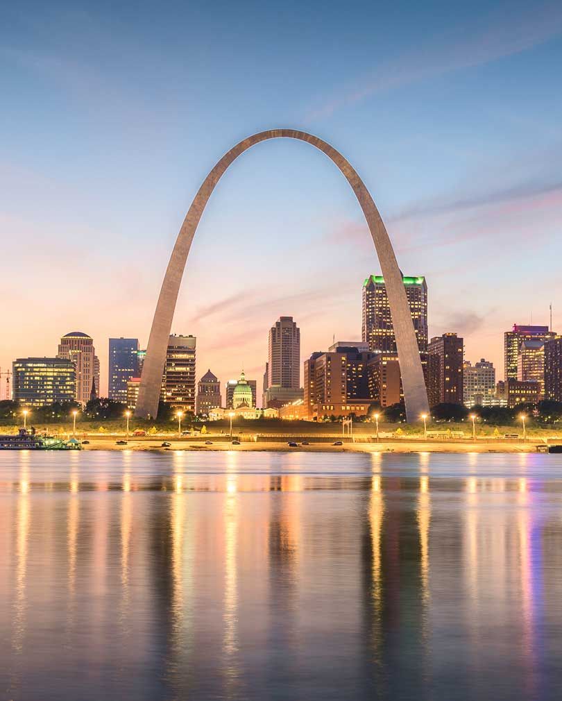 St. Louis Arch at sunset, city skyline reflection.