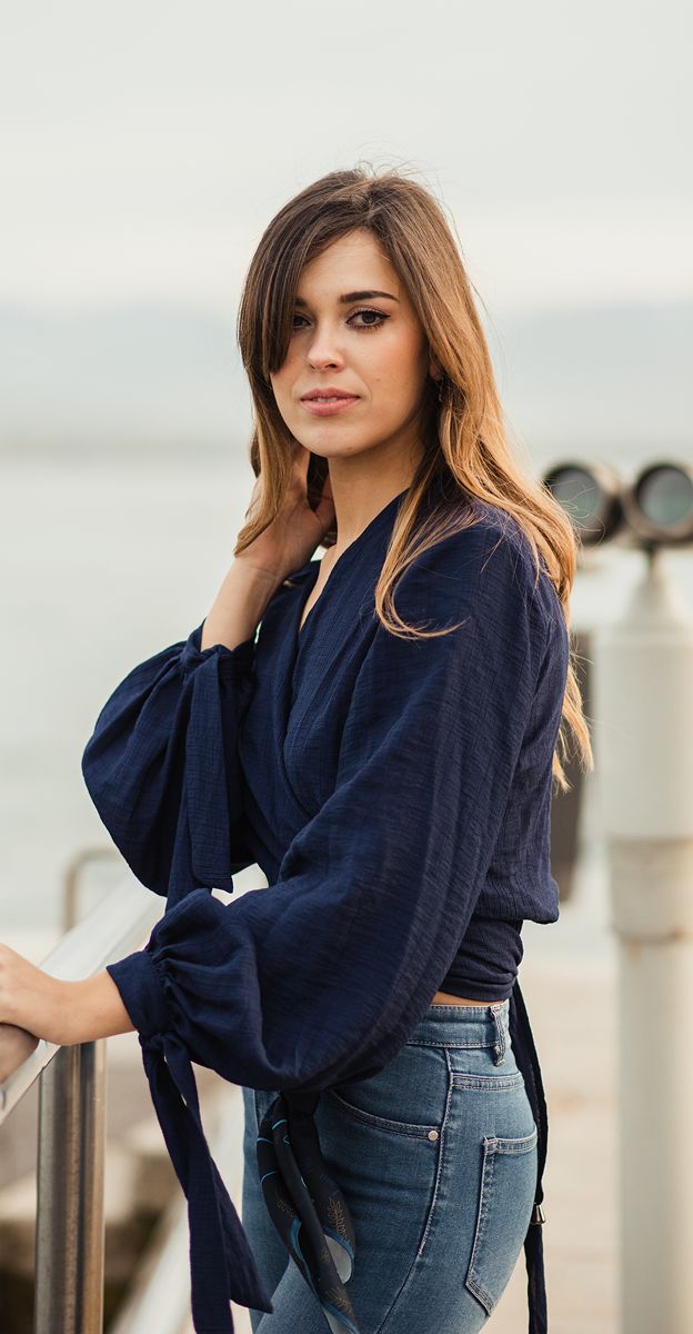 Woman in navy top by water railing.