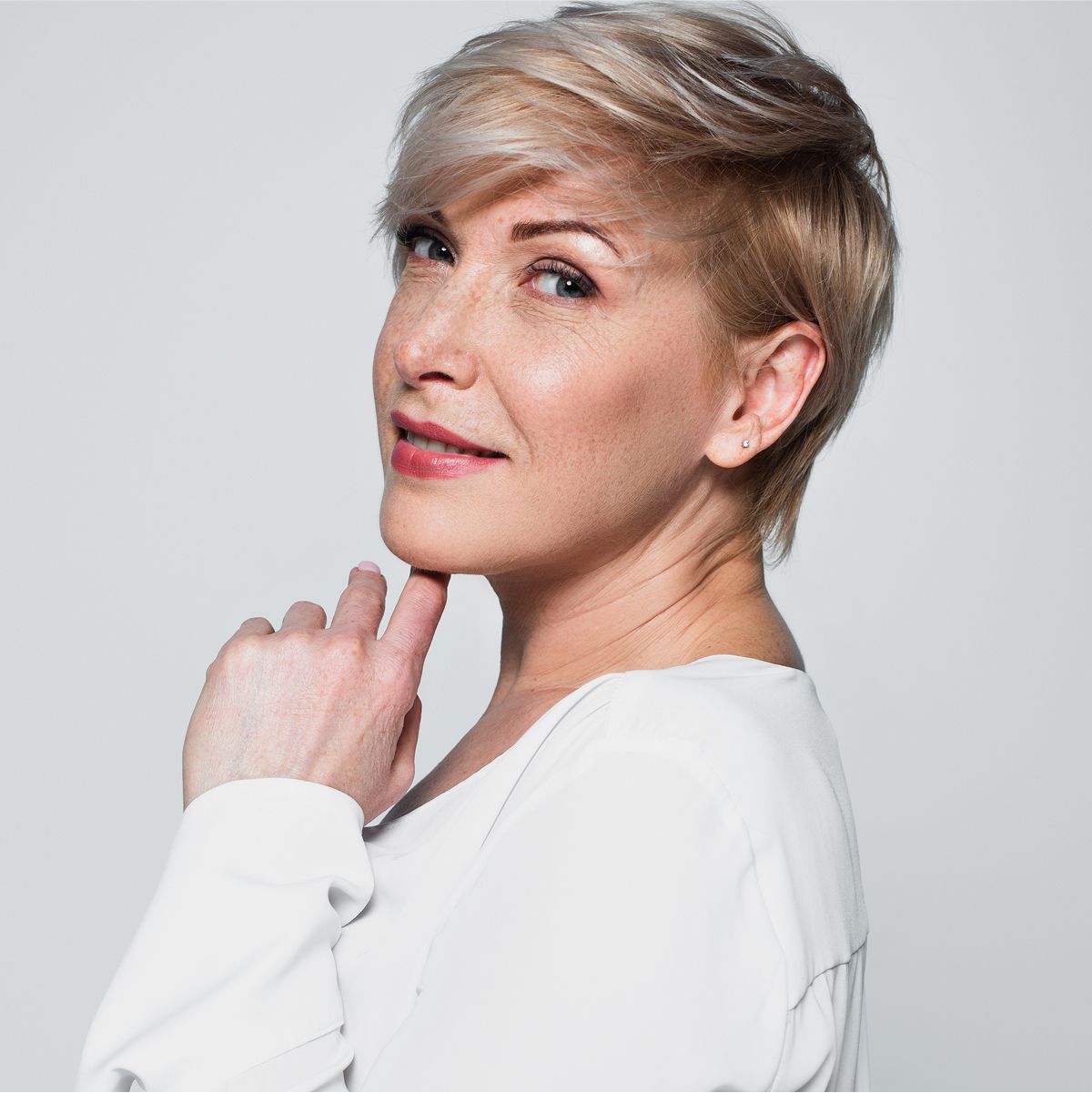 Woman with stylish short hair, smiling softly.