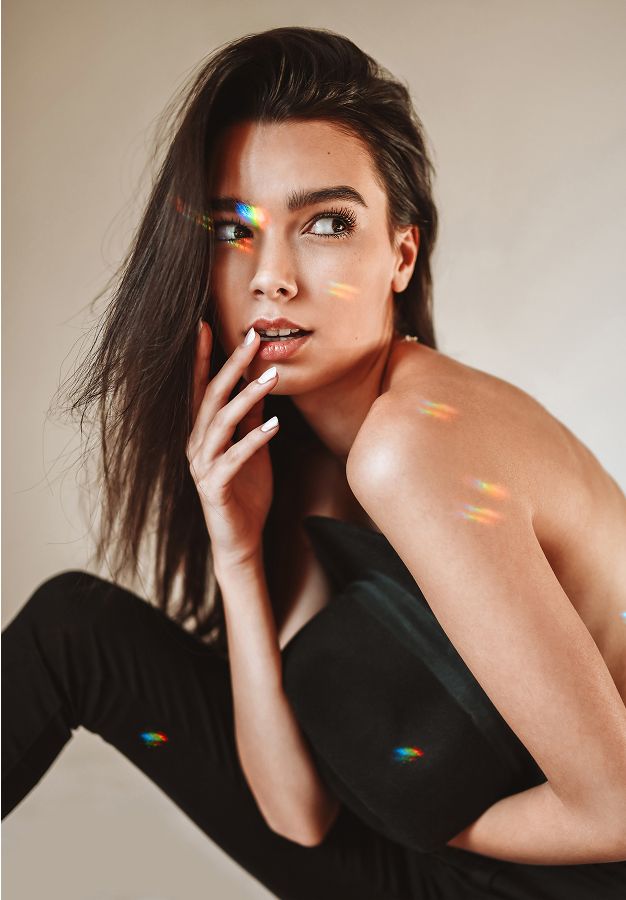 Model posing with playful light reflections.