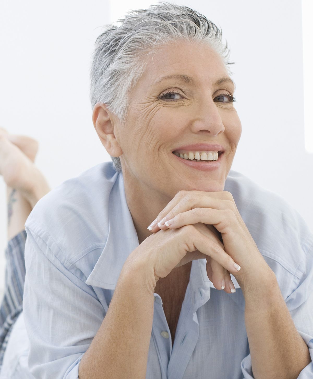 Smiling woman with freckles and curly hair.