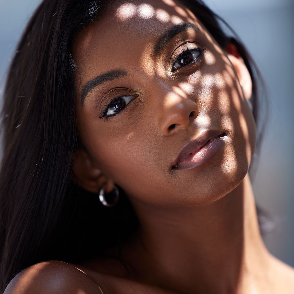 Woman's face with light and shadow patterns.