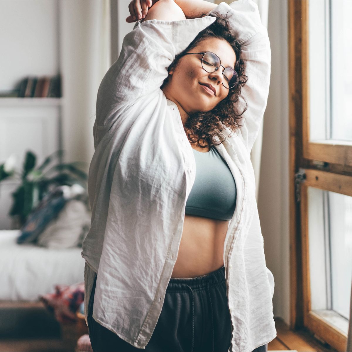 Person stretching in a bright, cozy room.