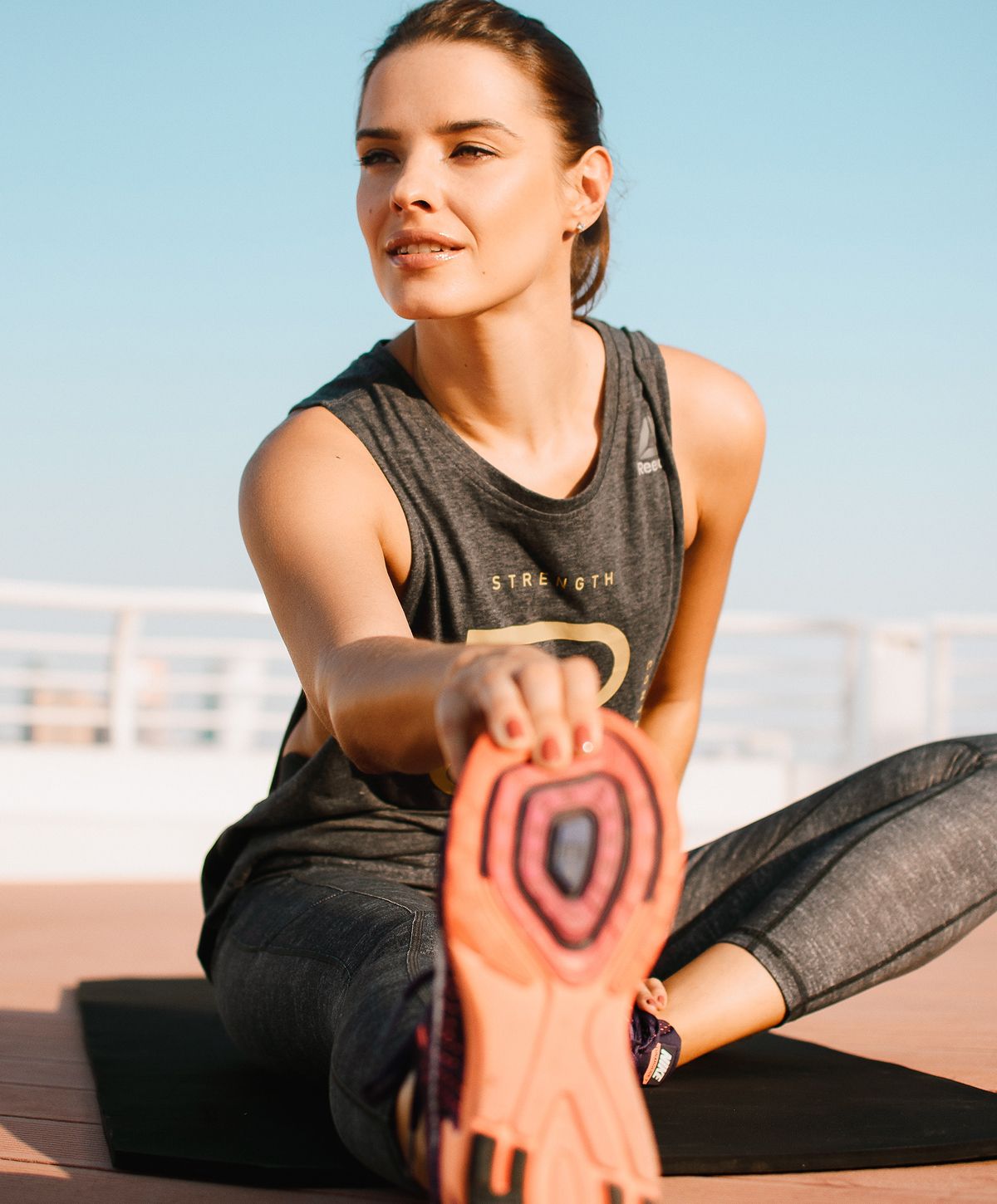 Woman in activewear with long, flowing hair.