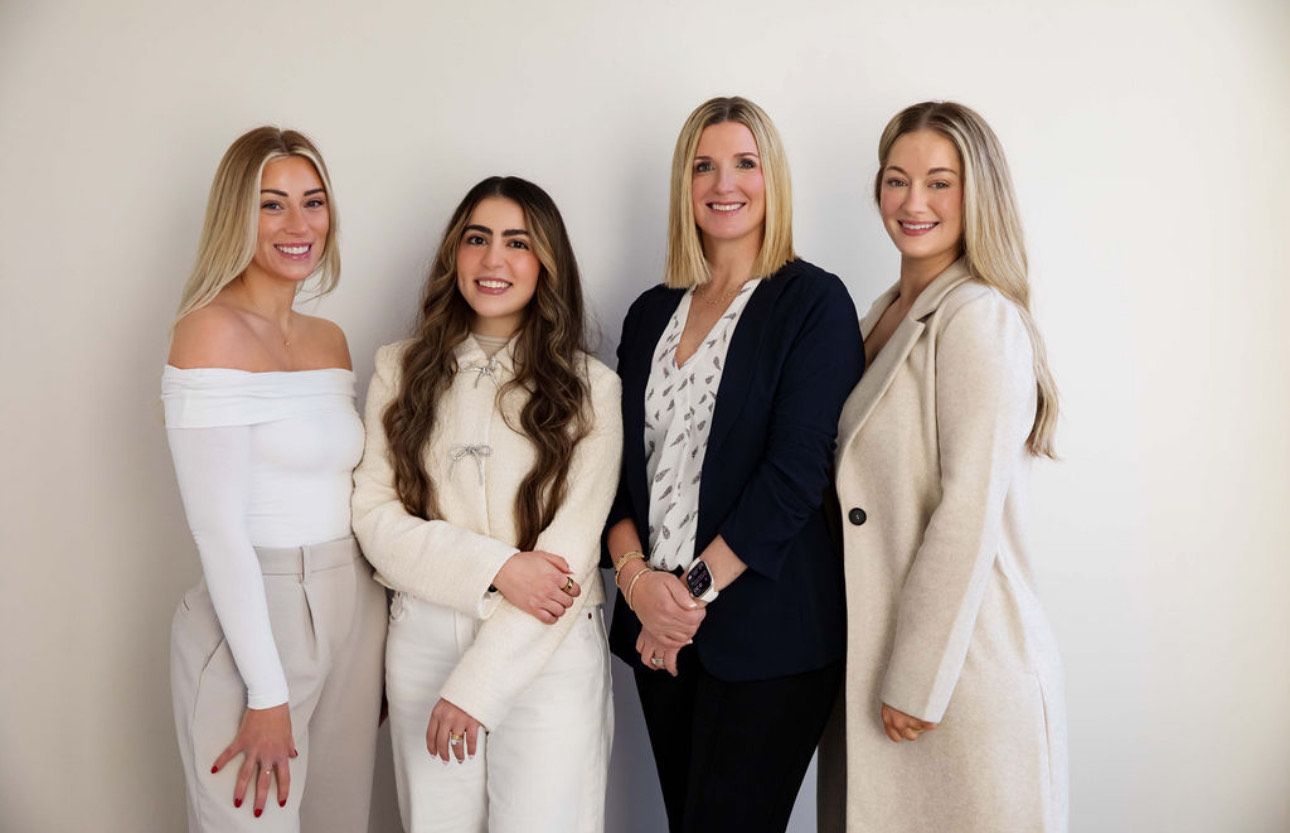 Four women posing in stylish outfits.