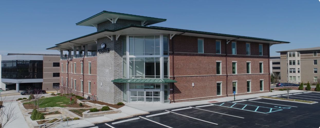 Bridge illuminated at night over calm water.