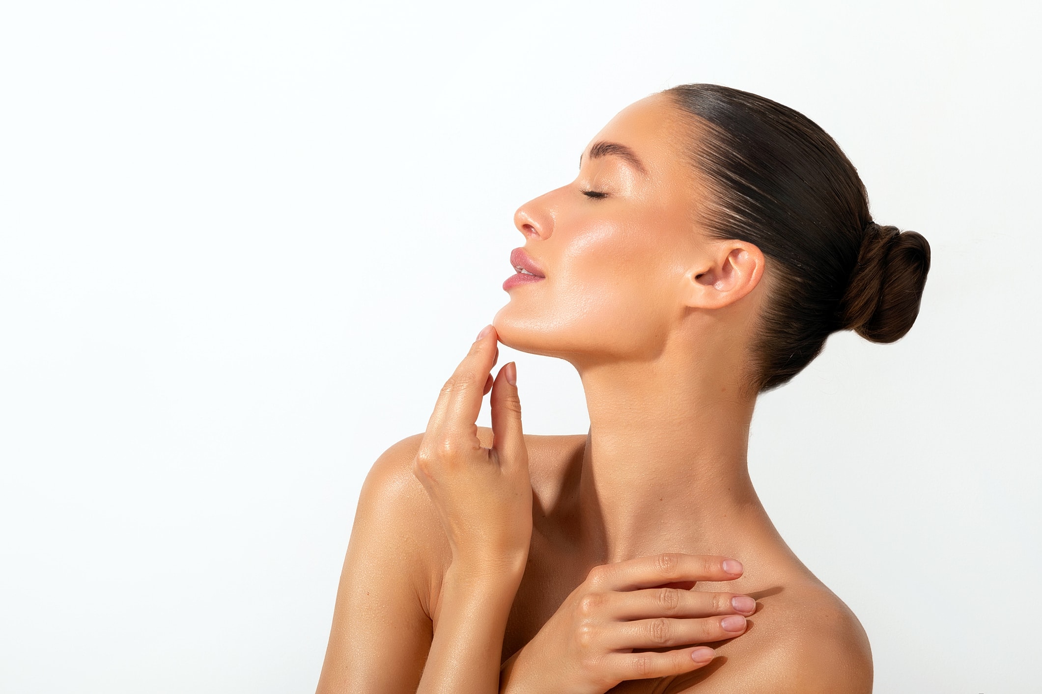 Woman with glowing skin and hands touching face.