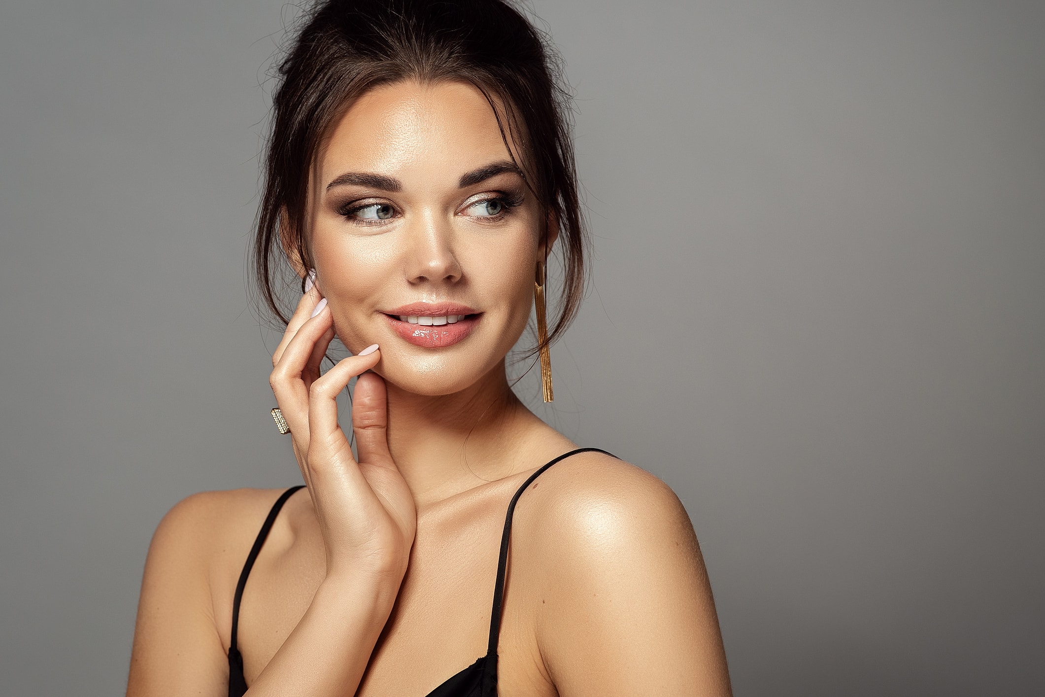 Smiling woman with elegant makeup and hairstyle.