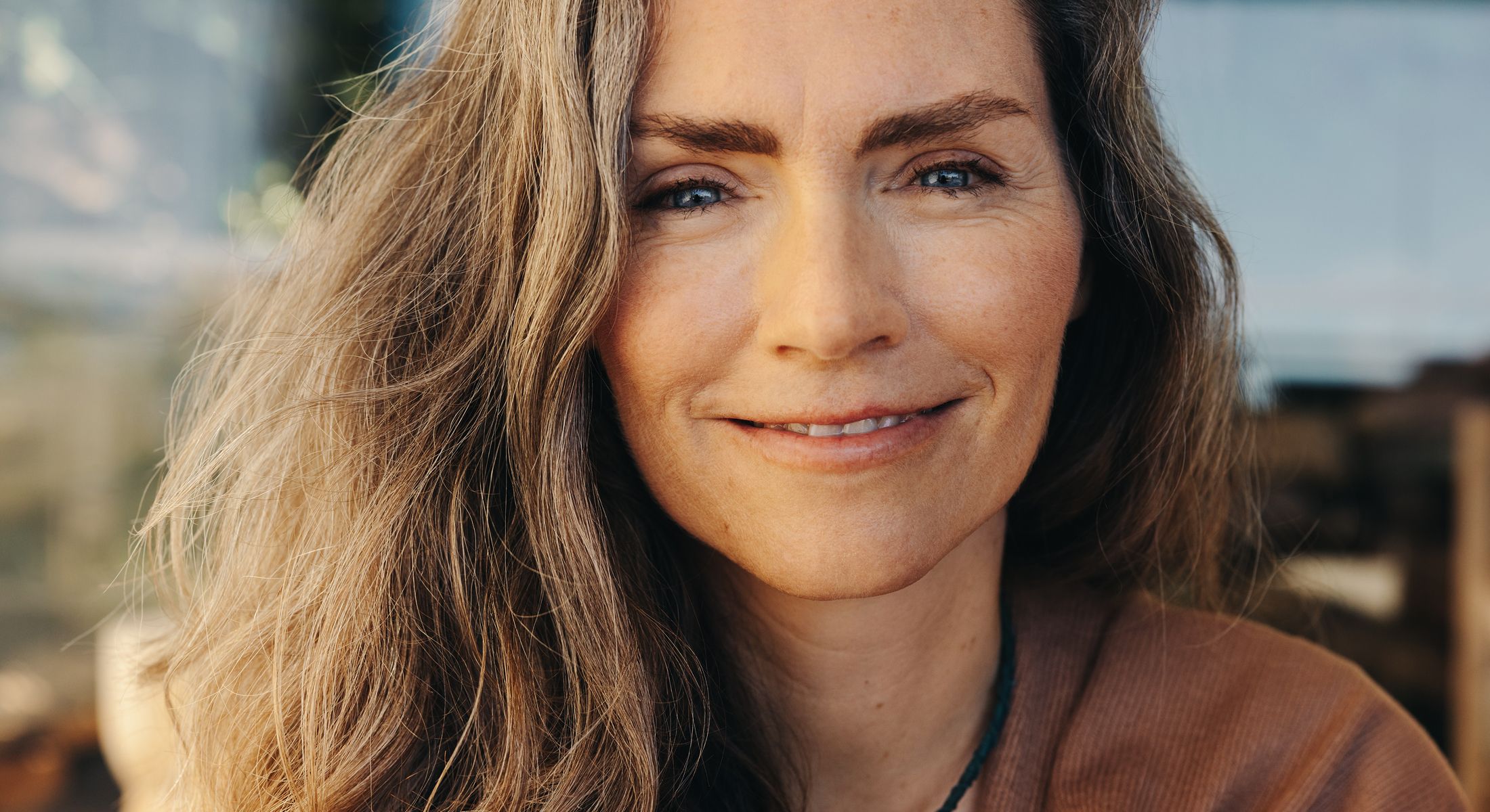 Smiling woman with long, wavy hair.