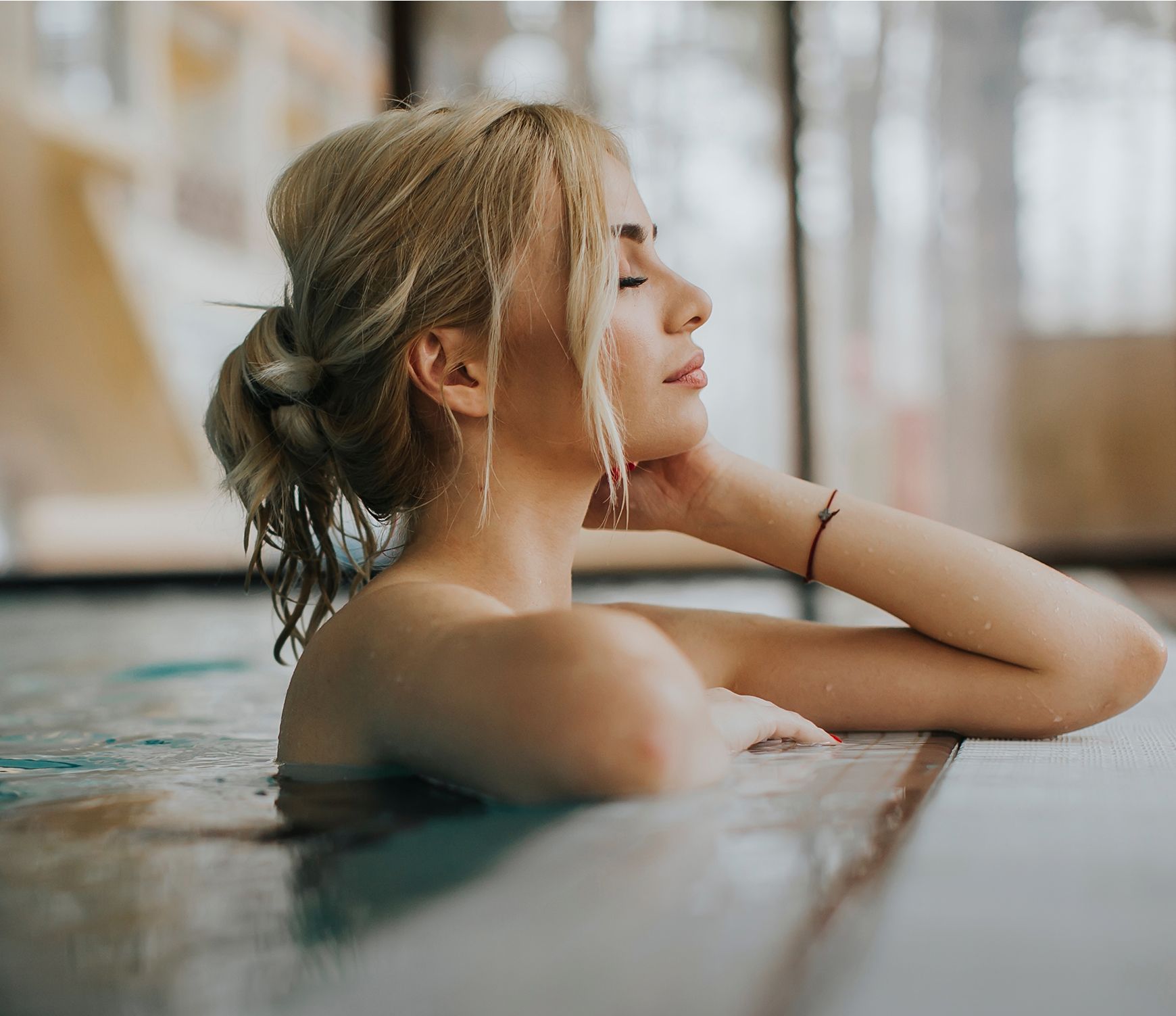 Woman relaxing in a pool, serene expression.
