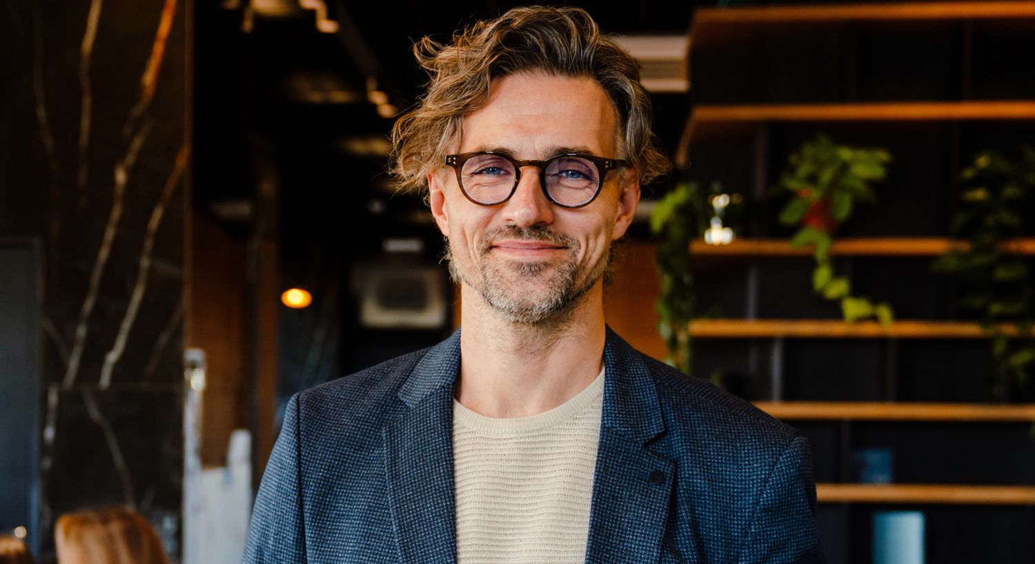 Smiling man in a stylish indoor setting.