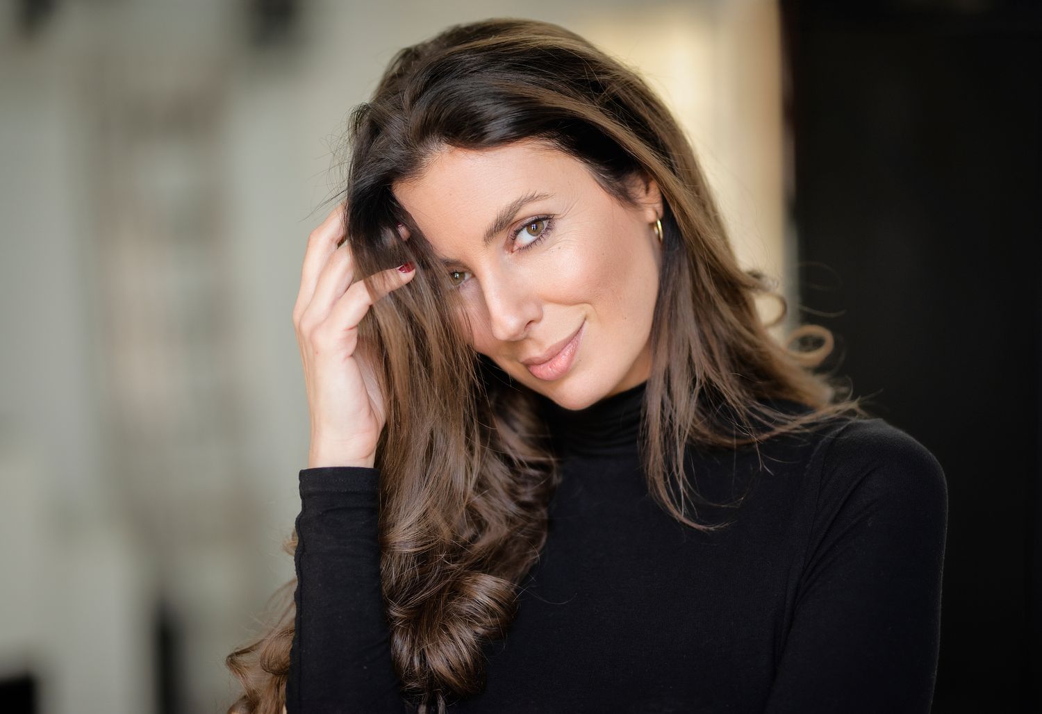 Woman with long hair and freckles, soft lighting.